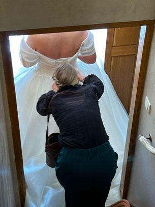 Morgane de My Daydream Wedding aide une mariée avec sa robe le jour du mariage