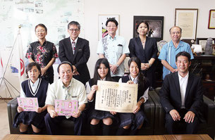 前列左から宮城はづきさん、諸見里明県教育長、知花萌香さん、與那城礼さん、環境工学部の指導を行った大城匡司教諭(現中部農林高校)=8日午後、県庁教育長応接室