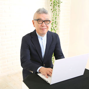 コーチがノートパソコンに文字を入力しながらこちらを見ている様子