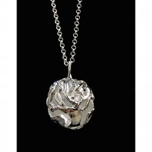 Un pendentif sphérique est suspendu à une chaîne en argent.