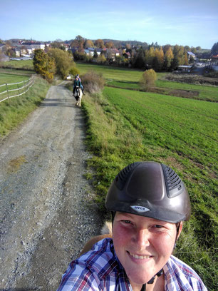 Pferde und Reiter auf einem Schotterweg