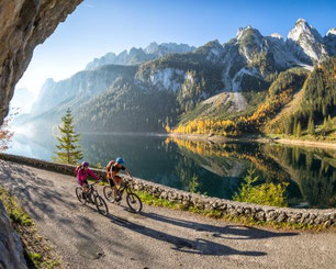 Radfahrer am Ufer des Gosausees mit Blick auf den Gosaukamm im Salzkammergut