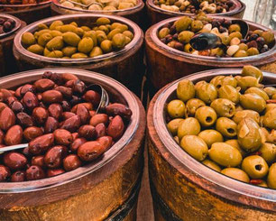 Regionale Produkte auf dem Bauernmarkt am Traunsee mit Oliven, Spezialitäten und Holzfässern