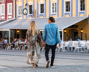 Paar spaziert durch das historische Zentrum von Mondsee mit Cafés und regionalem Flair