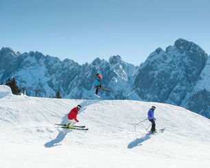 Skifahrer im Skigebiet Dachstein West mit Blick auf den Dachstein im Winter