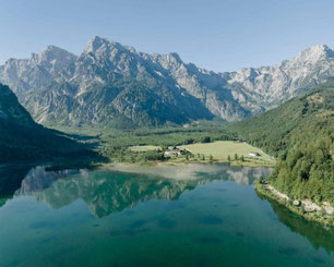 Panoramablick auf den Traunsee mit umliegender Berglandschaft und grünen Almen im Salzkammergut