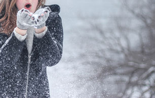 Content zum Thema Winter Mädchen bläst Schnee von Handschuhen