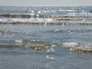 Sanfte Wellen im Meer, die Schaumkronen glitzern in der Sonne
