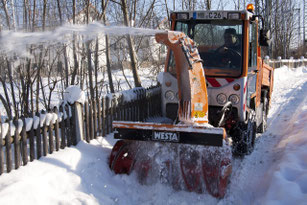 Winterdienstfahrzeug beseitigt Schnee in einer Nebenstraße