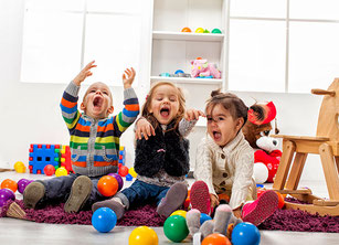 Drei kleine Kinder mit Spielzeug