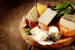 Mediterranean cheese selection on wooden board.