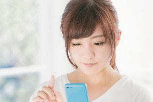 スマートフォン（スマホ）で確認する女性