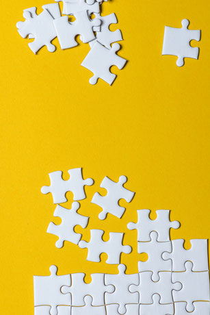 White puzzle pieces on a yellow background