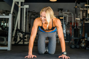 Frau beim Krafttraining im Fitnessstudio zur Unterstützung von Muskelaufbau und Muskelerhalt.