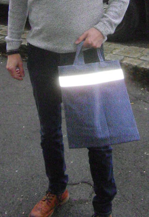 Tragtasche mit Reflektor - mit Blitz fotografiert. Ohne reflektiertes Licht erscheint der Streifen in neutralem Grau.