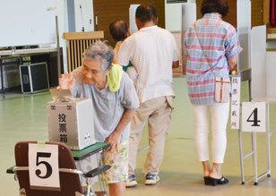 大原の投票区で投票する有権者=28日午前、西表大原