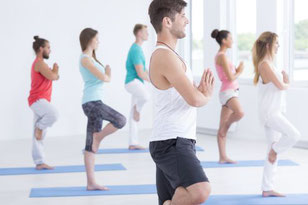 Mehrere Personen üben gemeinsam im Kurs Rückenyoga. Bild Photographee.eu/Fotolia