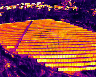 Thermografische Drohnenaufnahme eines Solarparks mit sichtbaren Hotspots und Temperaturabweichungen an Photovoltaikmodulen