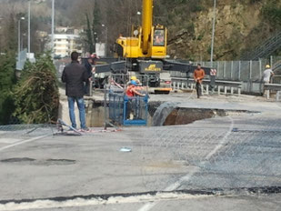 La gabbia con gli operai mentre viene calata sulla parete