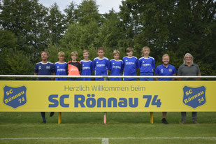 Junge schießt Ball zum Trainer