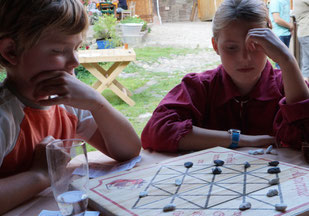 Kinder beim Brettspiel Alquerque zum Kindergeburtstag