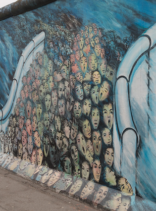 One of the artworks at the East Side Gallery in Berlin: a flood of people breaks through the Berlliner Wall