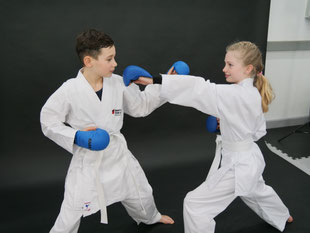 Karate Engen Kinder im Karate Anzug führen Technik aus. Stark und Selbstbewusst. Sicherheit und Selbstberteidigung. 