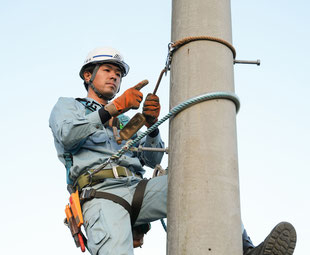 電柱に登る男性　株式会社橋本電設　丹波市