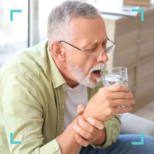 Älterer Mann mit zitternder Hand hält ein Glas – Behandlung von Tremor und Bewegungsstörungen in der Praxis Neuro im Zentrum St. Gallen