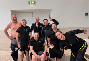 Gruppenbild mit Tauchern mit HAndicap, davon ein TAucher im Rollstuhl beim Inklusionstauchen