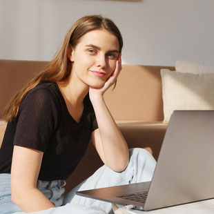 Frau sitzt vor einem Notebook