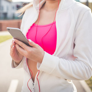 Joggerin blickt auf ihr Smartphone