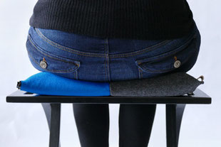 dynamisches Sitzen mit dem grau/blauem Flowmo Pad mittig aufrecht