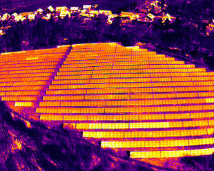Thermografische Drohnenaufnahme eines Solarparks mit mehreren Modulreihen zur Lokalisierung von Hotspots, Zellschäden und weiteren Fehlerbildern in Photovoltaikanlagen. 