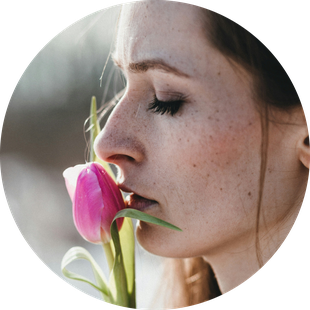 Frauengesicht geschlossene Augen, das an einer Tulpe riecht