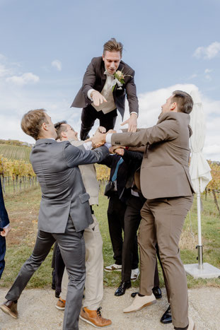 Ein Bräutigam wird bei einer Trauung in der Pfalz hochgeschmissen. Dies ist ein lustiges und unterhaltsames Gruppenfoto