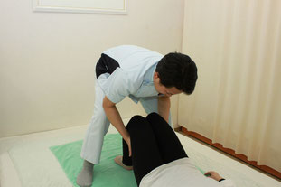 膝立姿勢で下腿牽引と揺らしを行い骨盤、腰背部から頚まで調整します。