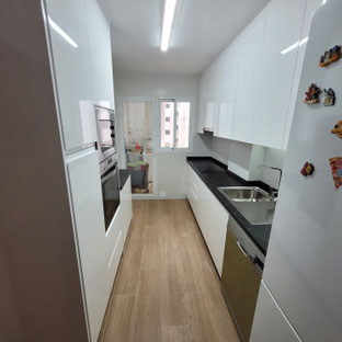 cocina en paralelo, cocina blanca brillo, cocina sin tiradores, tirador gola, cocina jaen, cocina torredelcampo, encimera negra, cocina estrecha, cocina pequeña