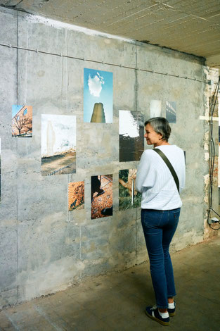 Eine Fraui schaut sich die Arbeiten von Christopher Horne in der Ausstellung wegsehen zwecklos an.