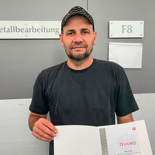 Ilijaz Smajic hält stolz sein Lehrabschlusszeugnis in Metallbearbeitung