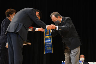 ガバナー特別賞のバナーを受取るL.樋口会長