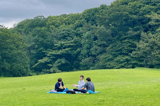 屋外で仲間と輪になり、思いを共有するグループ対話の場面