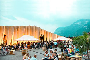 Besucher genießen den Aperitivo Panoramico auf der Terrasse der Kellerei Kurtatsch an der Südtiroler Weinstraße mit Wein, Musik und Bergpanorama.