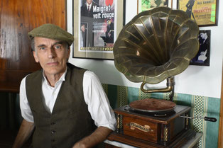 Thommi Baake sitzt im Café Sherlock neben einem alten Grammophon während Thommis Teatime