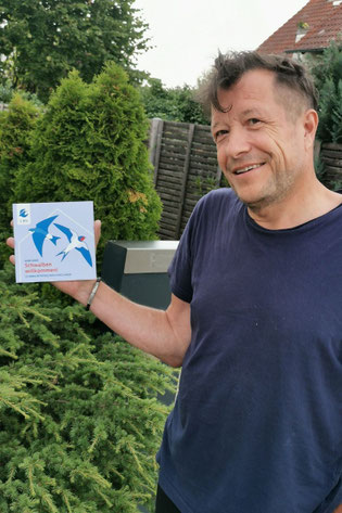 Herr Kahl aus Cadolzburg mit der Plakette "Schwalbenfreundliches Haus" (Foto: Hans-Georg Müller)