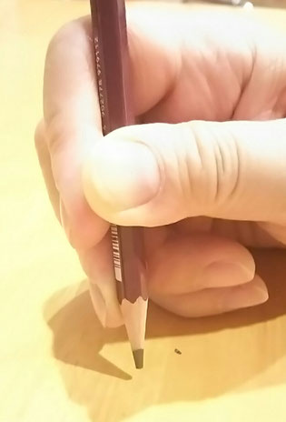 中指が鉛筆の上に乗っている