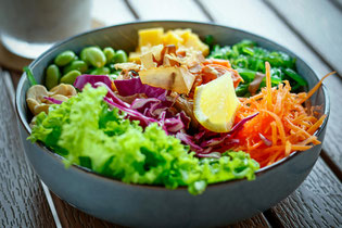Leckere Bowl mit Edamame, Rotkraut, Salat und Karotten