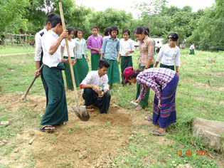 OISCA coordinator teaches students how to plant seedlings.