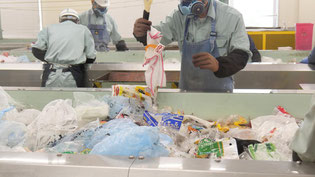 日野市クリーンセンター・プラスチック類資源化施設の「プラスチック類手選別室」における手作業による選別の様子。プラスチックの再資源化には、このような手作業による選別作業が欠かせません。