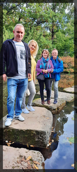 Der Autor Matthias Berns und seine Gäste auf dem Wasser Weg über den Teich des japanischen Gartens im Chempark Leverkusen